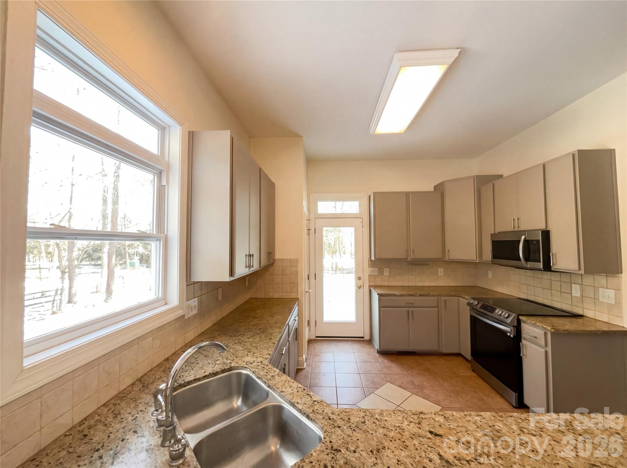 405 Isle Of Pines Road Mooresville, NC 28117 - Photo 9 of 18 a large kitchen with kitchen island granite countertop a stove top oven a sink a dining table and chairs