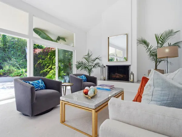 a living room with furniture fireplace and a large window