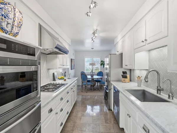 a kitchen with stainless steel appliances a sink stove and cabinets