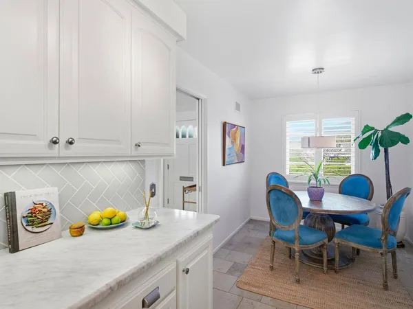 a view of dining table chairs and window in a kitchen