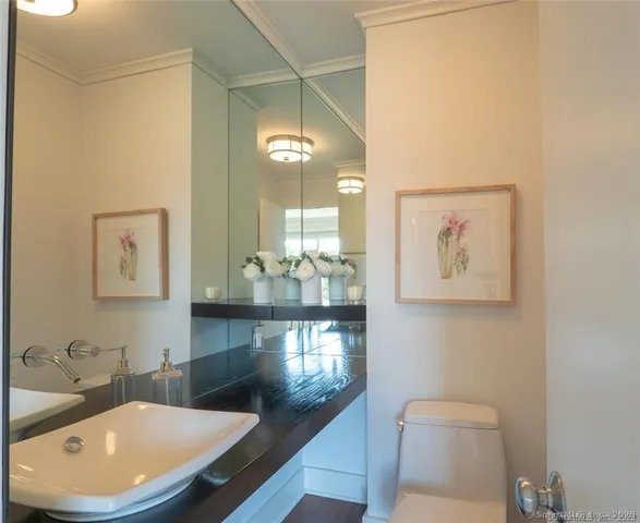 a bathroom with a granite countertop toilet a sink and a mirror