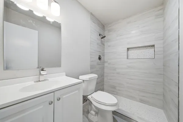 a bathroom with a sink a toilet and shower