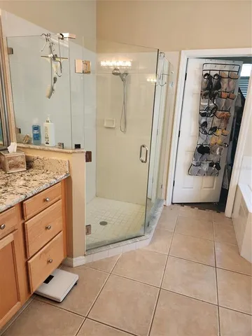 a bathroom with a granite countertop sink a mirror and shower