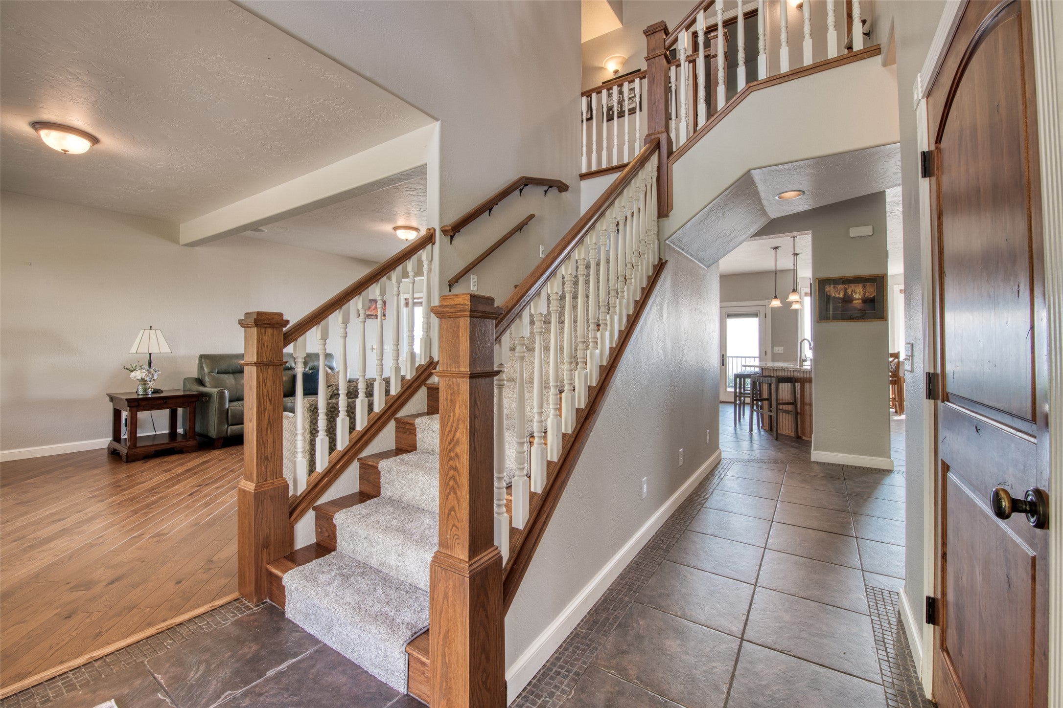 16374 Folsom Road Florence, MT 59833 - Photo 59 of 98 Staircase with a textured ceiling, tile patterned flooring, and a high ceiling