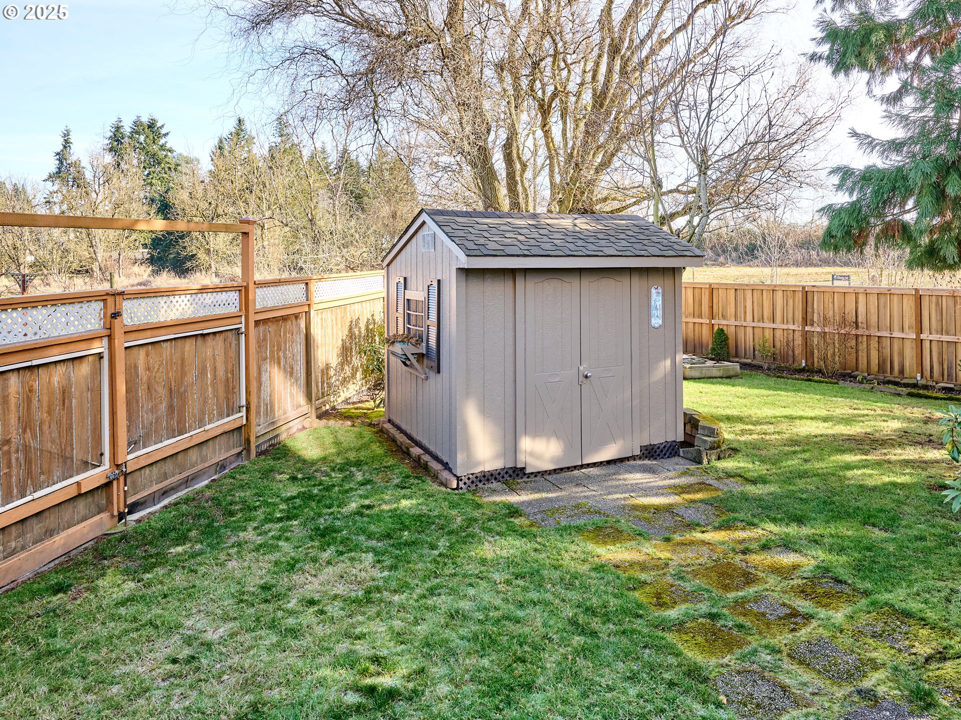 920 Hermanson Street Woodburn, OR 97071 - Photo 37 of 48 a view of a backyard with large tree and wooden fence