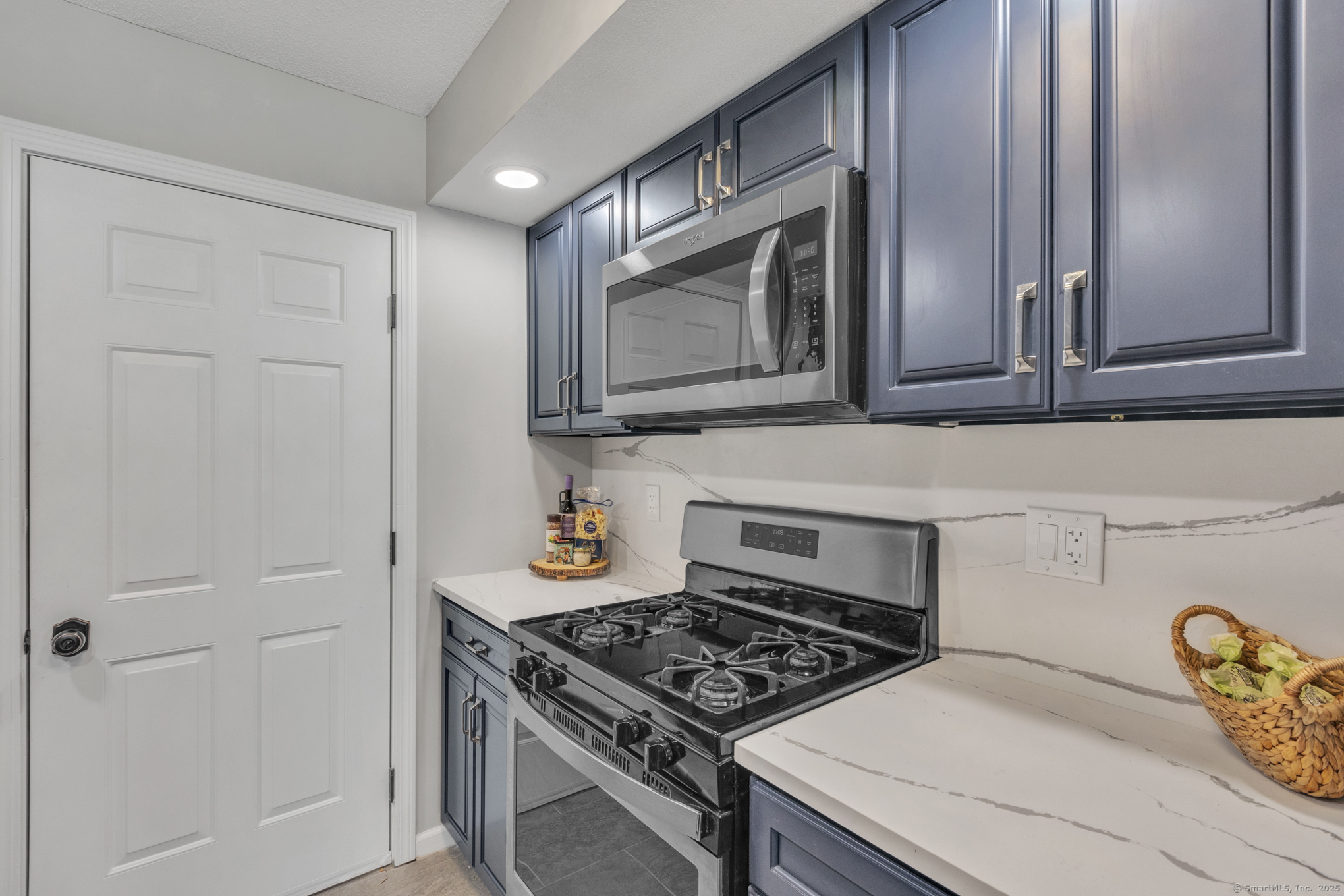 16 Maple Street, Unit 11 Vernon, CT 06066 - Photo 11 of 29 a kitchen with stainless steel appliances granite countertop a stove a microwave and cabinets