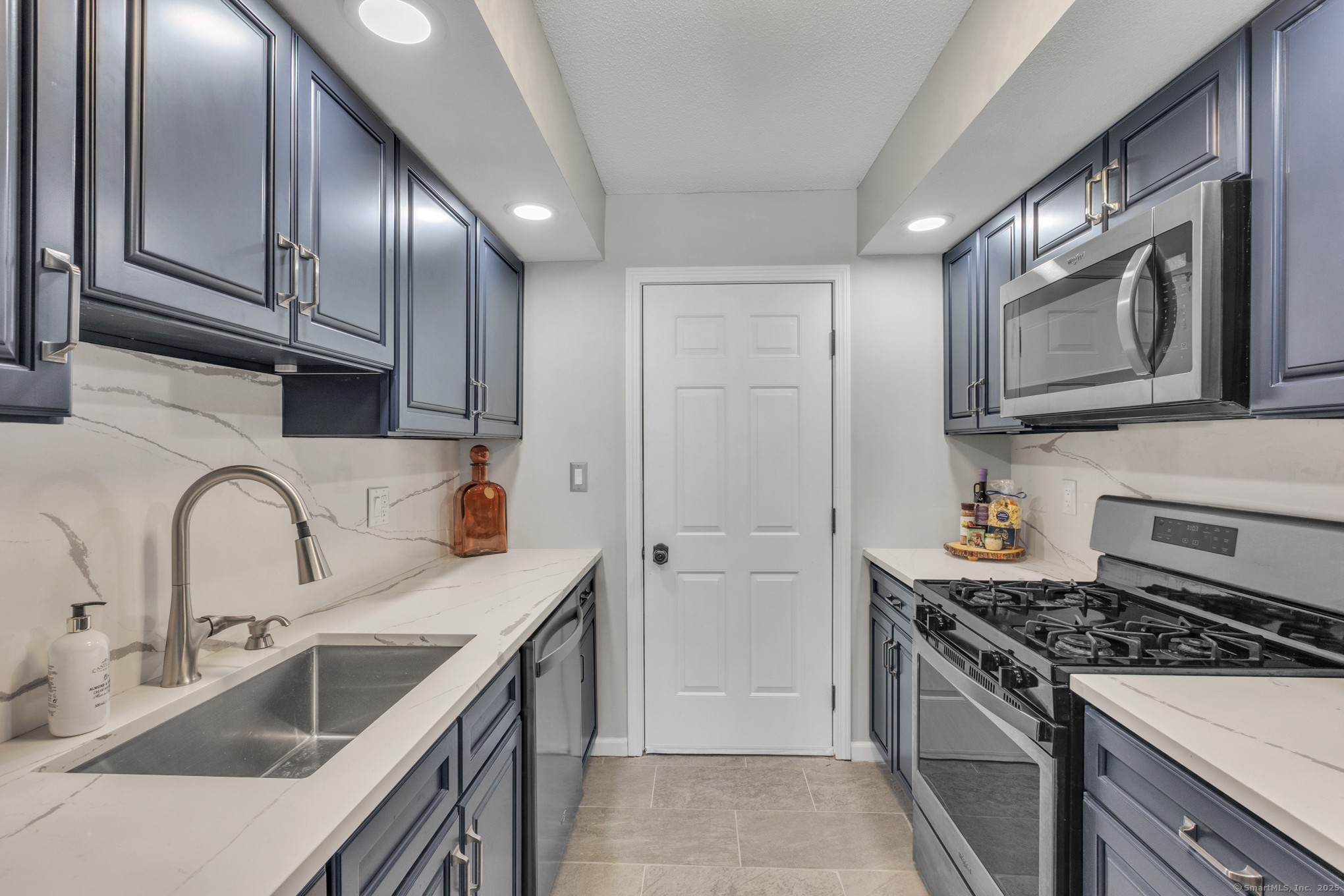16 Maple Street, Unit 11 Vernon, CT 06066 - Photo 9 of 29 a kitchen with stainless steel appliances granite countertop a sink stove refrigerator and cabinets