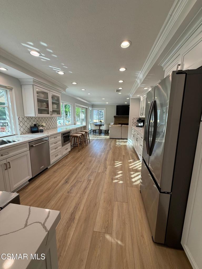 259 Sinaloa Road Simi Valley, CA 93065 - Photo 6 of 17 a kitchen with stainless steel appliances granite countertop a refrigerator a sink dishwasher a stove and white countertops with wooden floor