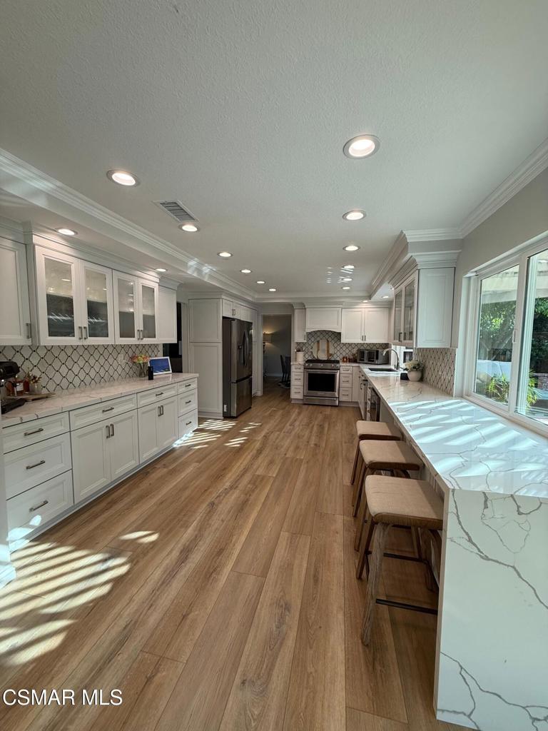 259 Sinaloa Road Simi Valley, CA 93065 - Photo 7 of 17 a large kitchen with stainless steel appliances kitchen island a large counter top a stove and a sink