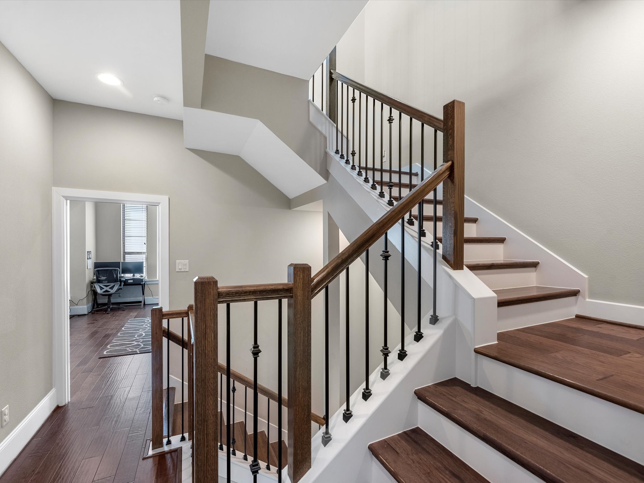 5467 Larkin Street Houston, TX 77007 - Photo 22 of 33 a view of staircase with lots of frames on wall and wooden floor