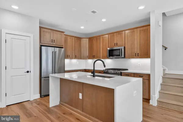 a kitchen with stainless steel appliances granite countertop a refrigerator sink and cabinets