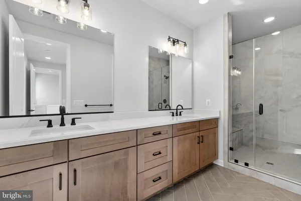 a bathroom with double vanity sinks and a shower