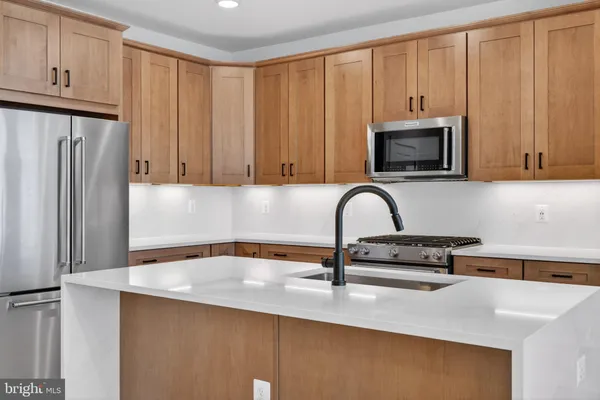 a kitchen with granite countertop white cabinets and stainless steel appliances