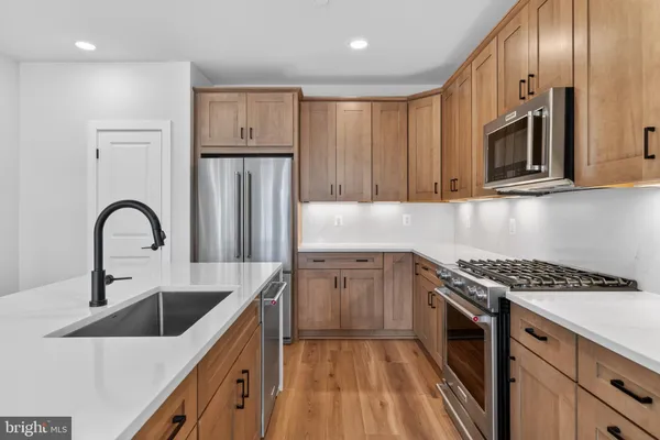 a kitchen with stainless steel appliances granite countertop a sink stove and refrigerator
