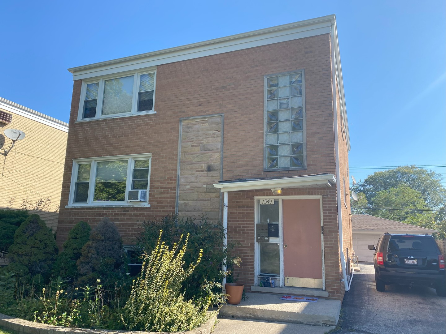 front view of a brick house with a small yard