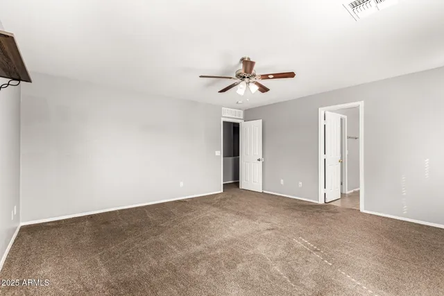 a view of an empty room with a ceiling fan
