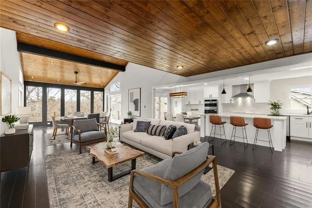 an empty room with wooden floor ceiling fan and windows