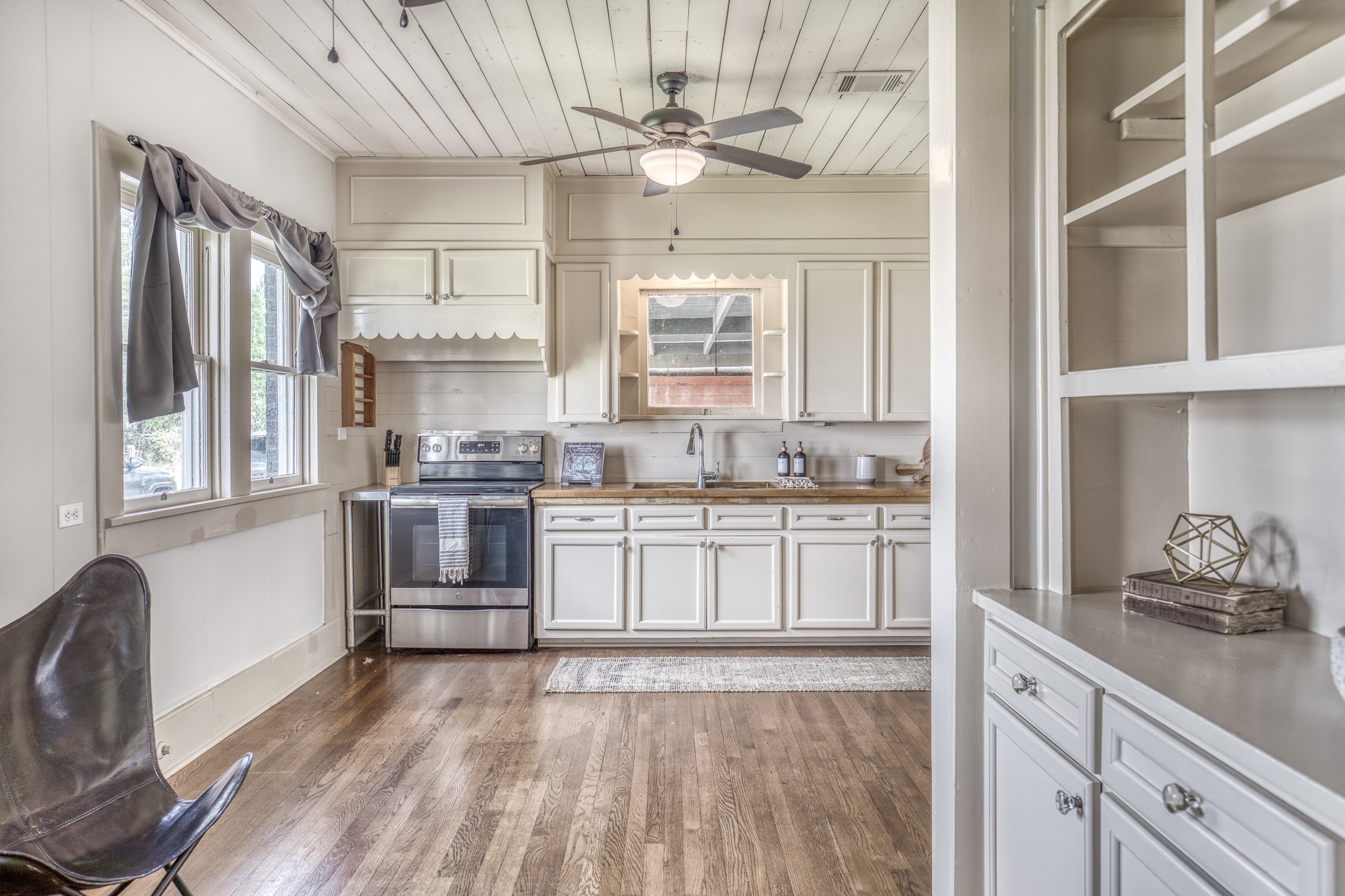 404 West Main Street Bellville, TX 77418 - Photo 8 of 36 a kitchen with granite countertop a stove a sink and white cabinets with wooden floor