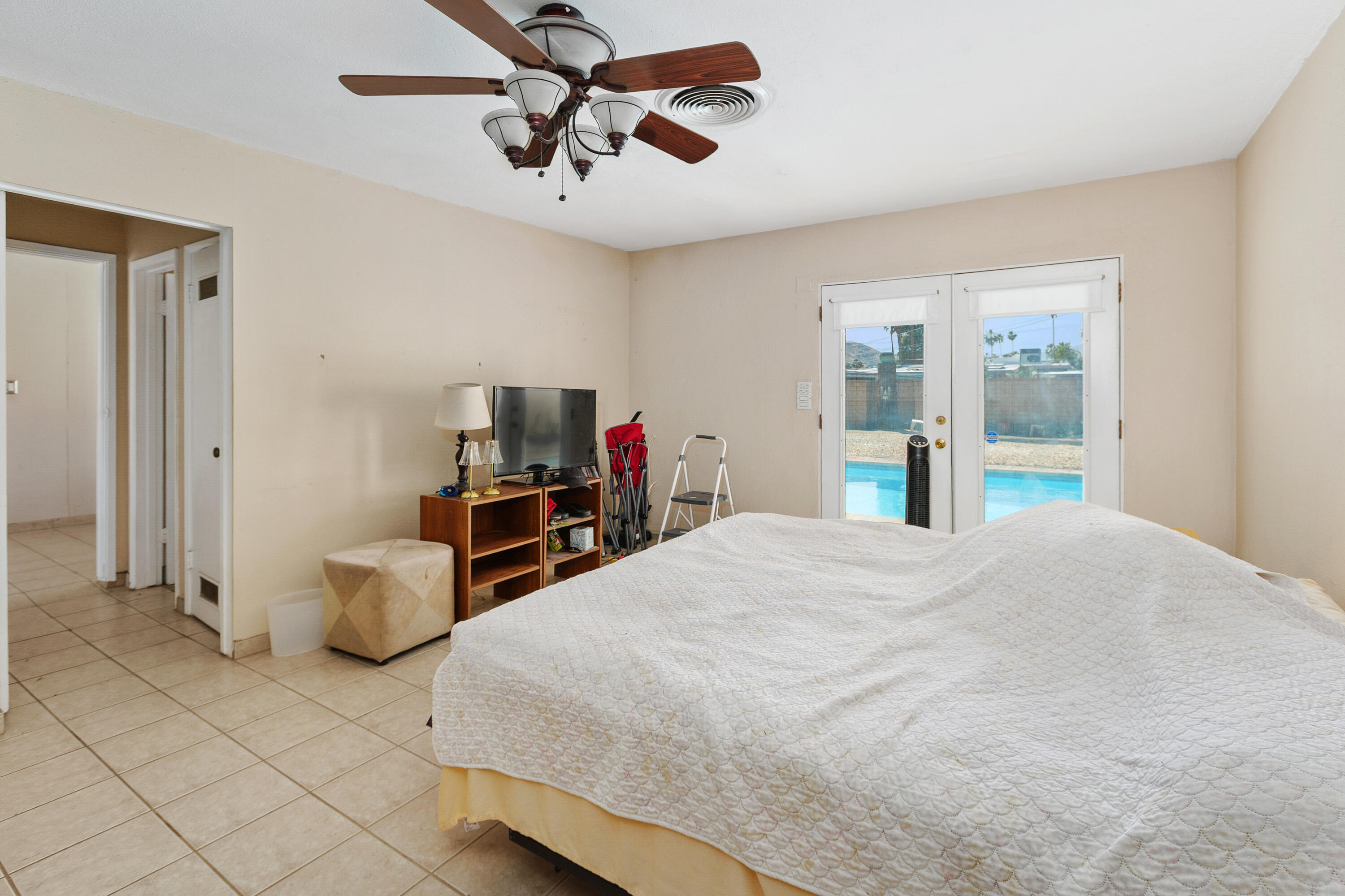 1077 South Riverside Drive Palm Springs, CA 92264 - Photo 26 of 35 a bedroom with a bed and a chandelier