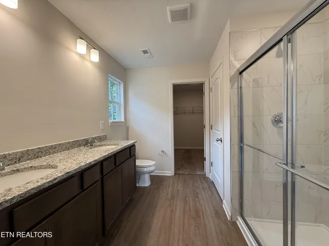 a bathroom with a granite countertop sink toilet and shower