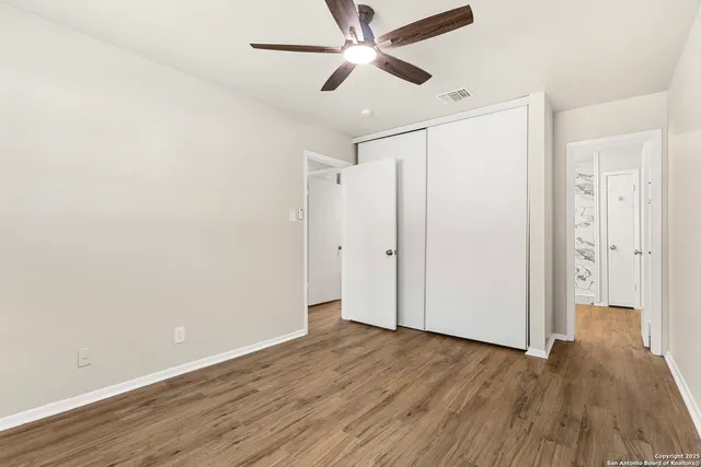 a view of an empty room with wooden floor