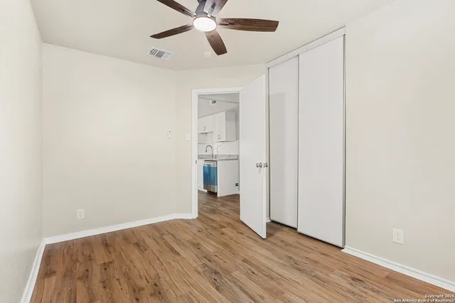 a view of an empty room with wooden floor
