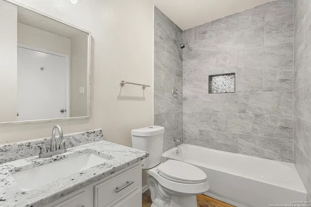 a bathroom with a granite countertop sink toilet and shower