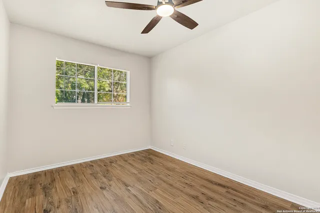an empty room with a window and wooden floor