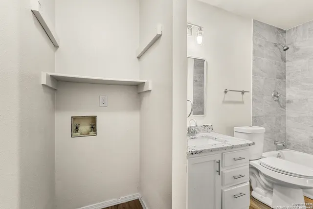 a bathroom with a granite countertop sink toilet and shower