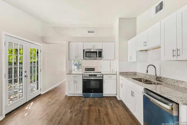 a kitchen with stainless steel appliances granite countertop a sink stove and refrigerator
