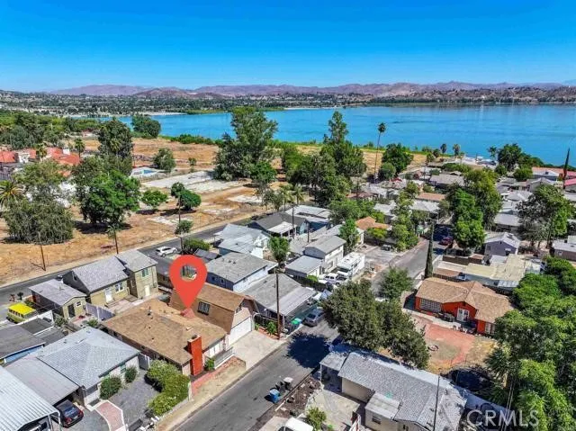 an aerial view of a city with lots of residential buildings and ocean view in back