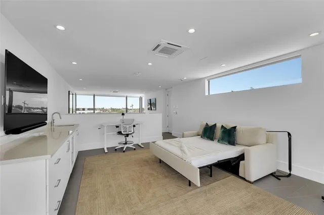 a bedroom with a large bed and a flat tv screen next to a large window
