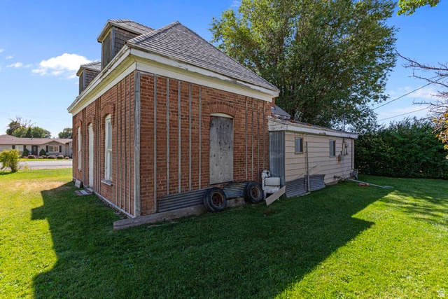482 West 100 N Street Beaver, UT 84713 - Photo 32 of 41 View of back of property featuring a yard, brick siding, and roof with shingles