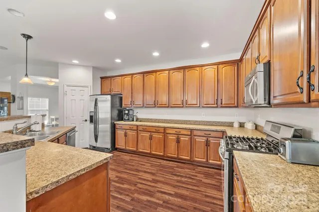 a kitchen with stainless steel appliances granite countertop a sink refrigerator and cabinets