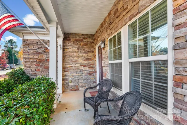 a view of a porch with chairs and a potted plant