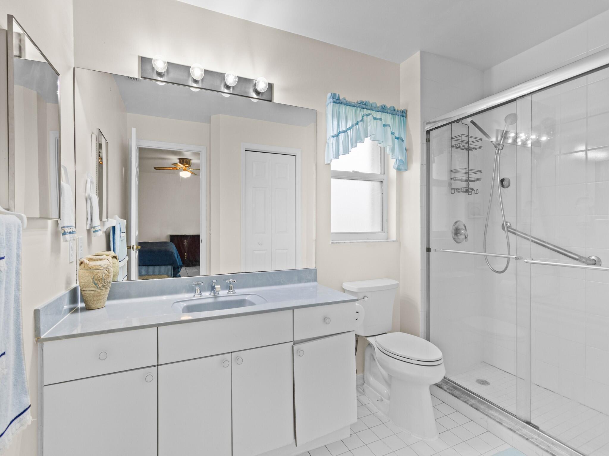 992 Seneca Avenue Sebastian, FL 32958 - Photo 17 of 26 a bathroom with a granite countertop shower sink vanity mirror and toilet