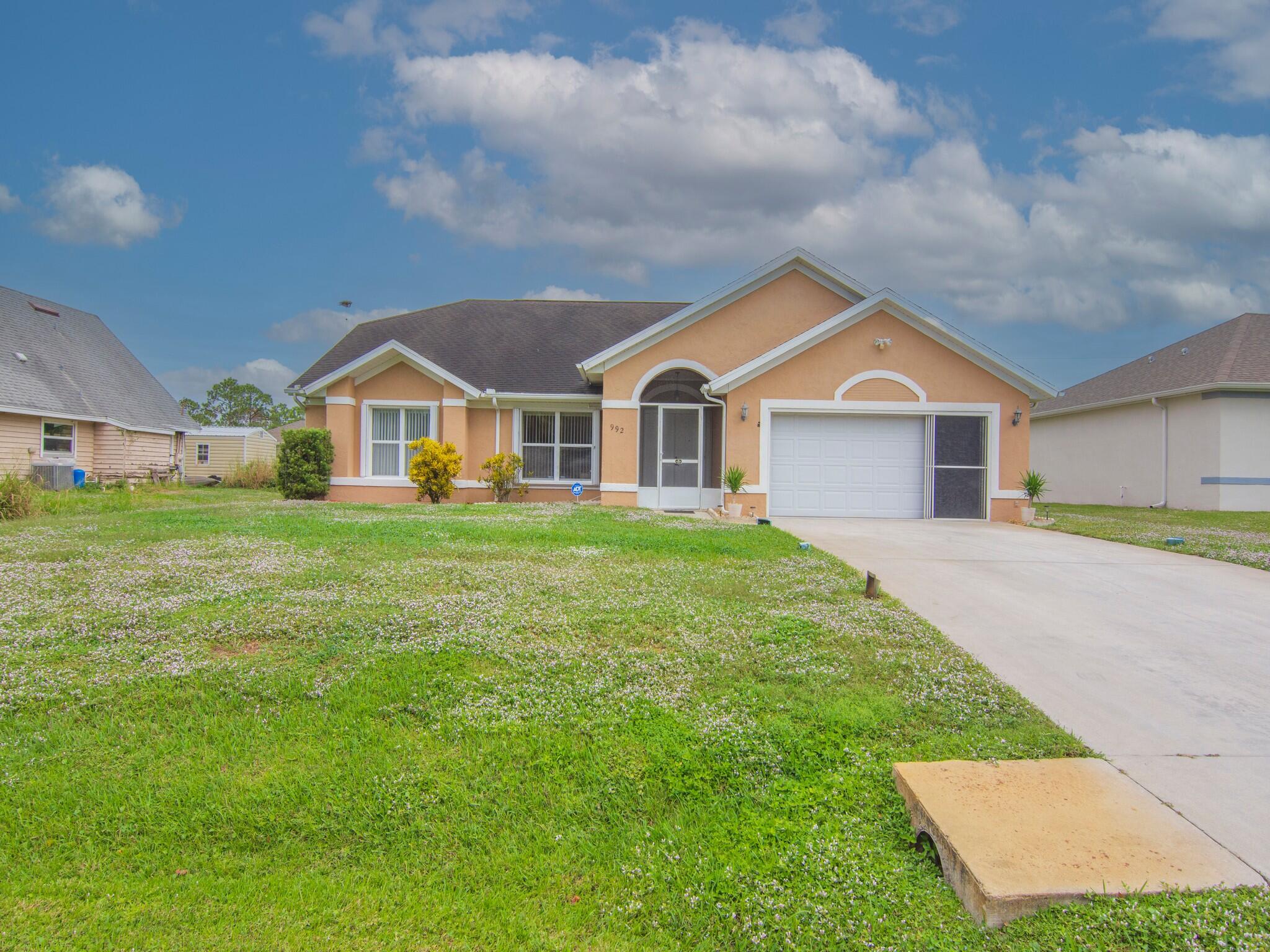 992 Seneca Avenue Sebastian, FL 32958 - Photo 2 of 26 a front view of a house with a garden and trees
