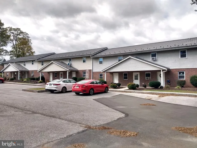 a front view of a house with a garden and parking space