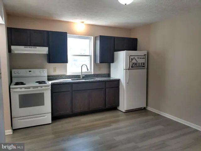 a kitchen with a sink a stove a refrigerator and cabinets