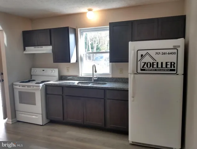 a kitchen with a sink cabinets and wooden floor