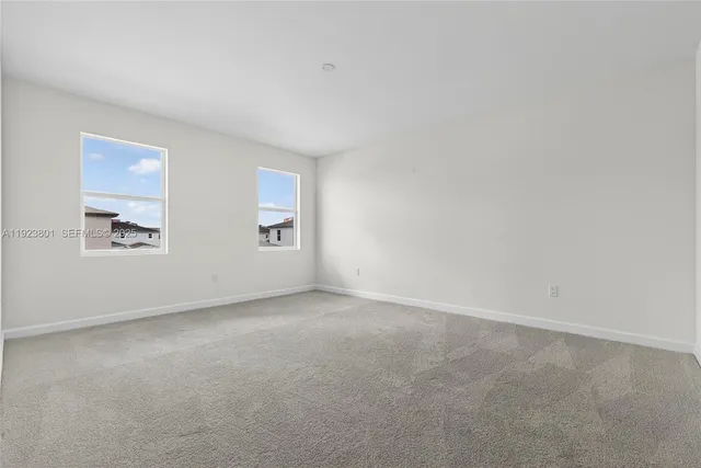 a white toilet sitting next to a white wall