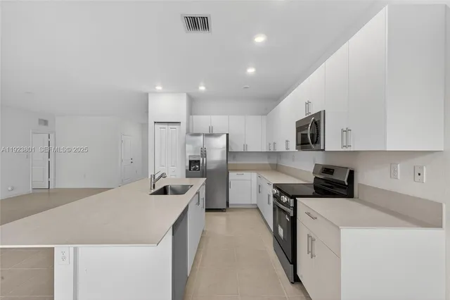 a kitchen with granite countertop a sink a stove and cabinets