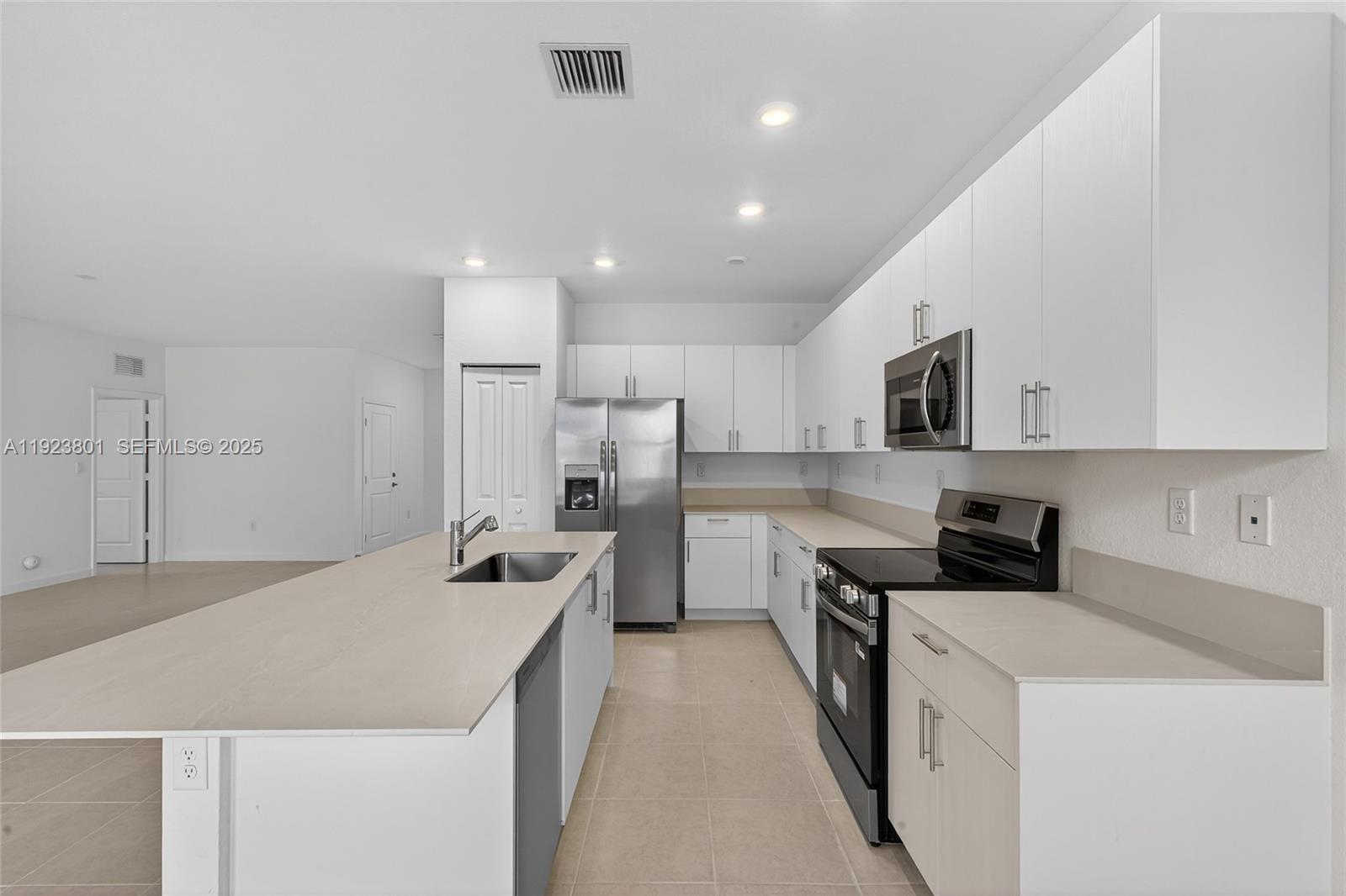19431 Southwest 340th Street Homestead, FL 33034 - Photo 24 of 48 a kitchen with stainless steel appliances a sink stove and white cabinets