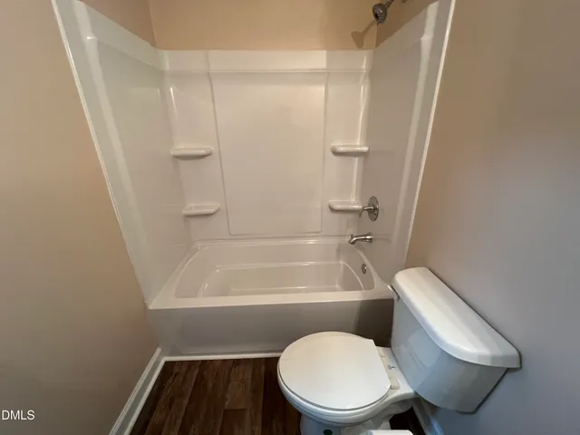 a white toilet and tub next to a white cabinet