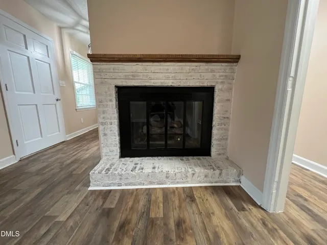 a living room with a fireplace and wooden floor