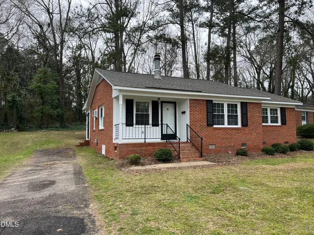 a front view of a house with a yard and trees