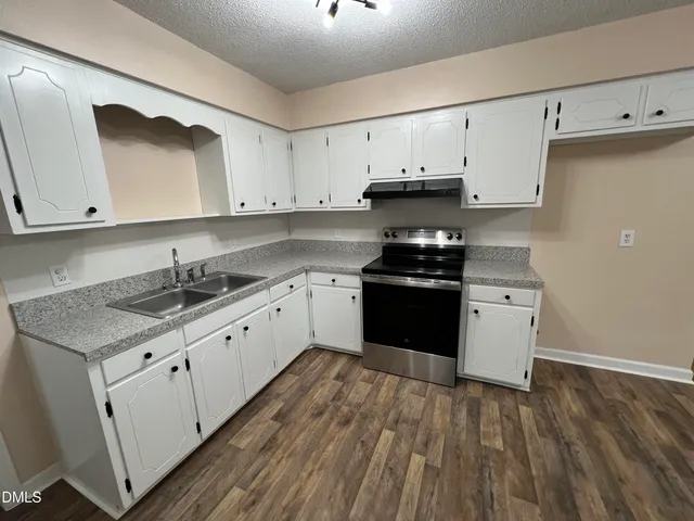a kitchen with granite countertop white cabinets and white appliances