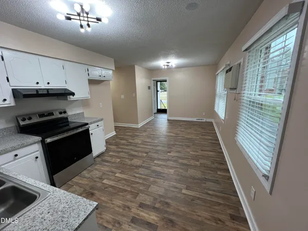 a kitchen with granite countertop a stove a sink and a refrigerator