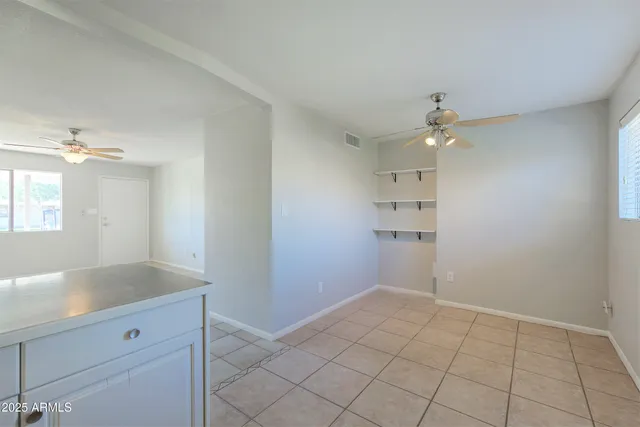 a view of an empty room with a chandelier fan