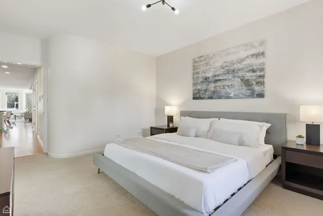 a bedroom with a bed and a painting on the wall